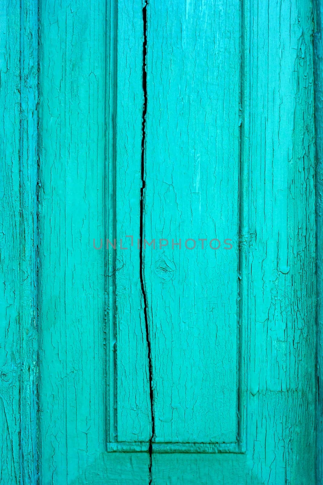 Fragment of old cracked wooden board painted in turquoise color