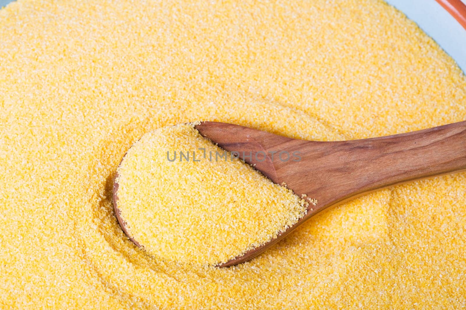 Wooden spoon in bowl of polenta