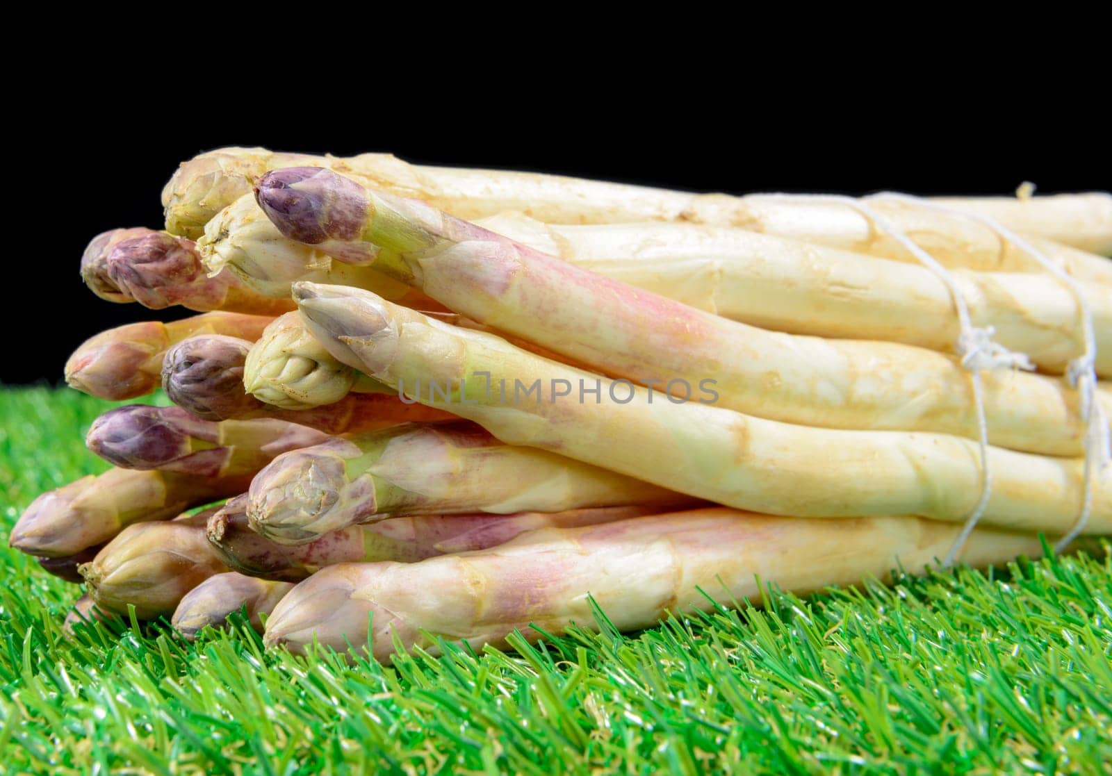 a bunch of fresh asparagus on the black background
