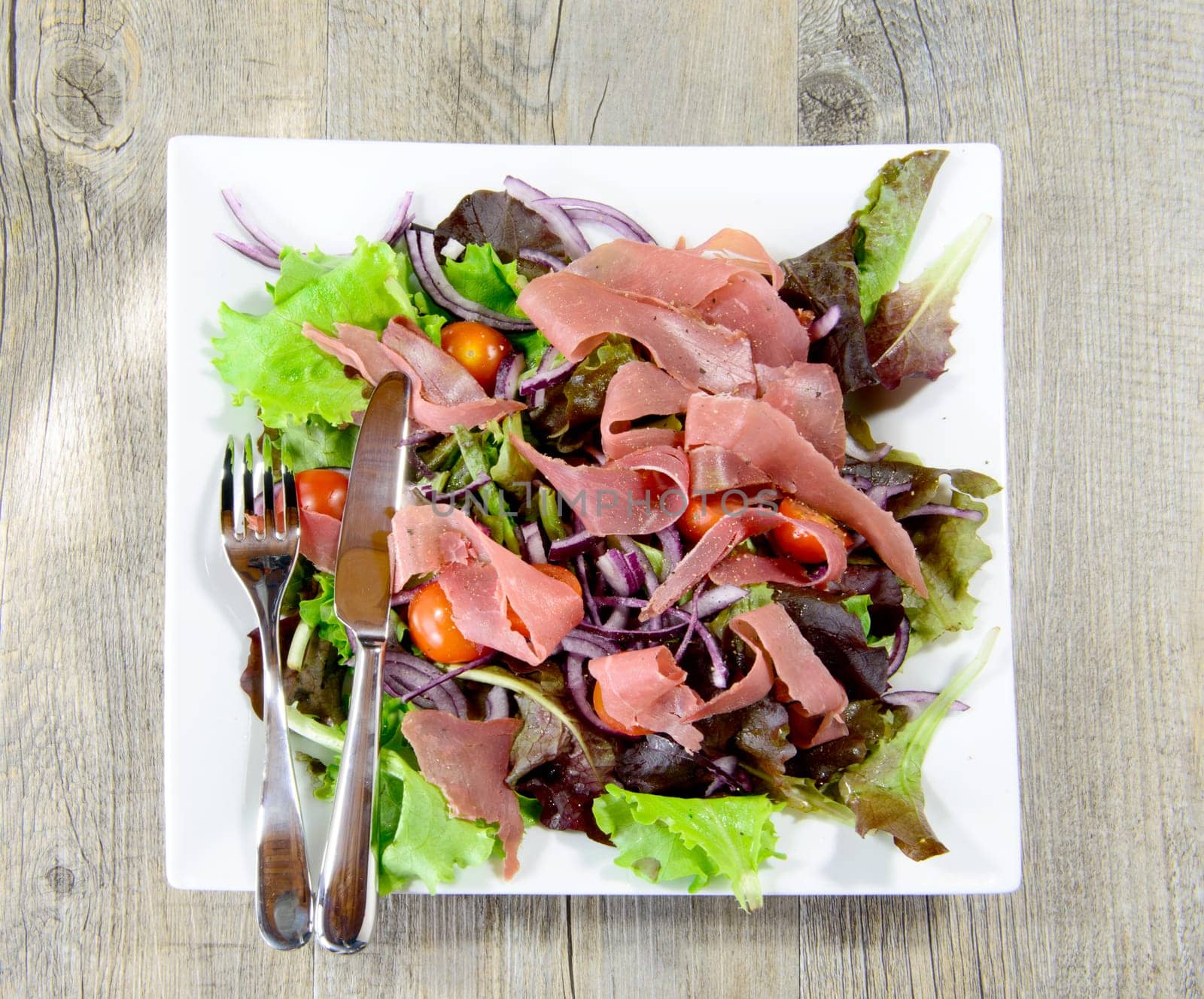 plate of ham and salad with cultery