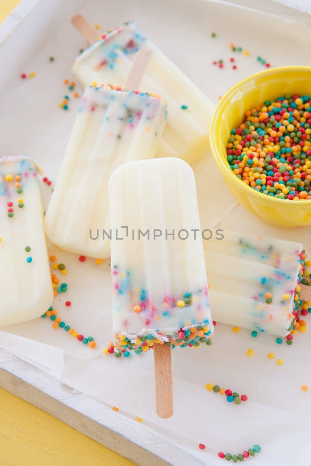 Homemade vanilla ice cream on the stem with colorful sprinkles