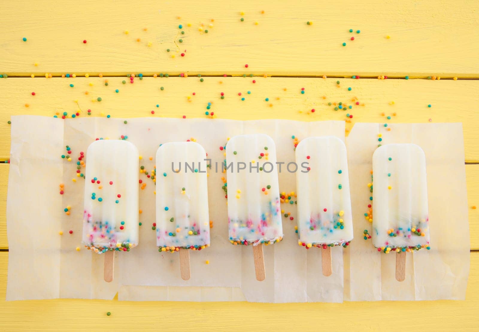 Homemade vanilla ice cream on the stem with colorful sprinkles