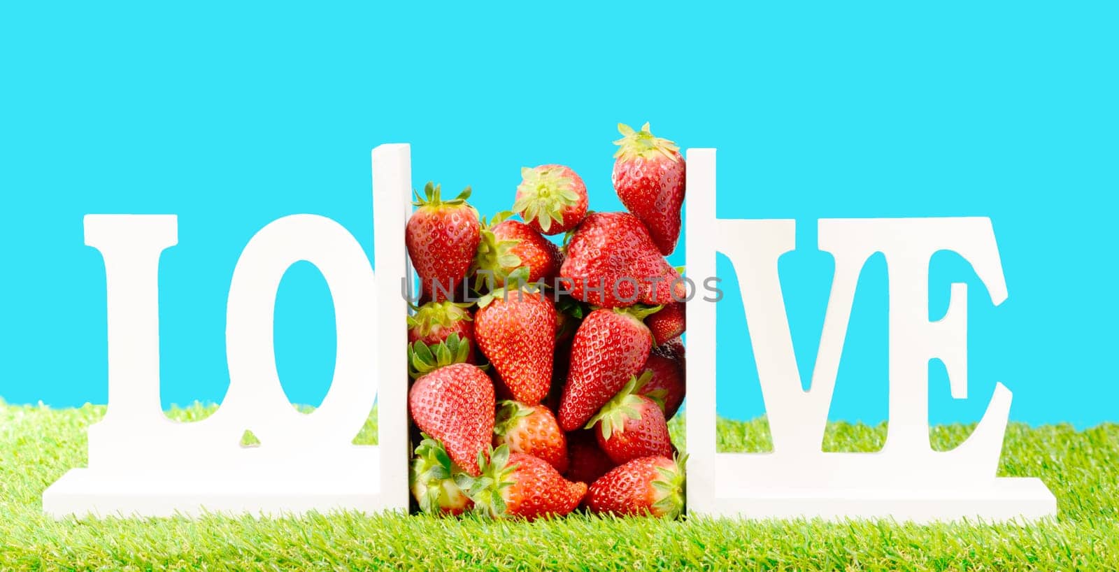 several strawberries on green grass with bright colors
