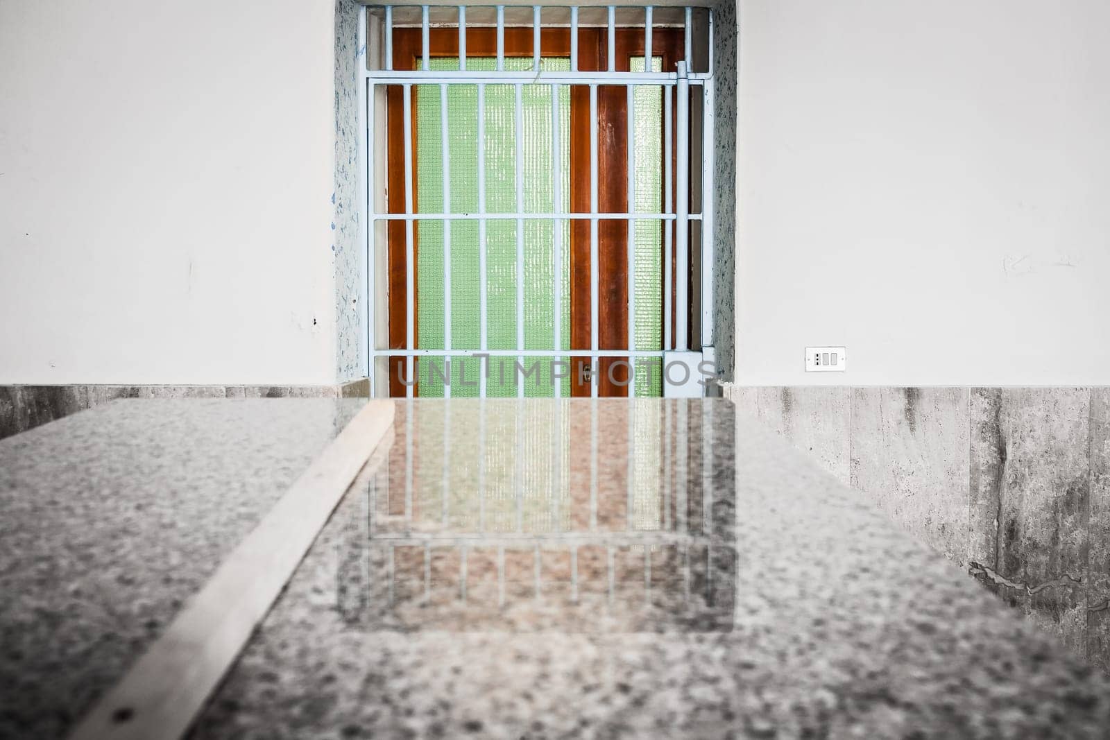 Barred and colorful  door with reflection on granite table
