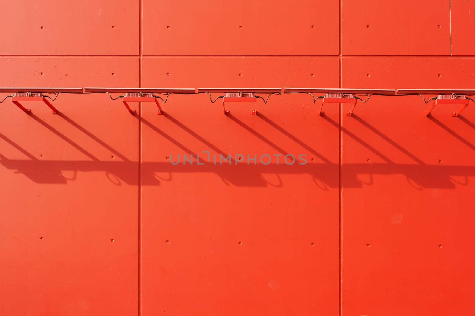 The lamp strips of a distinctive red facade cast a shadow.