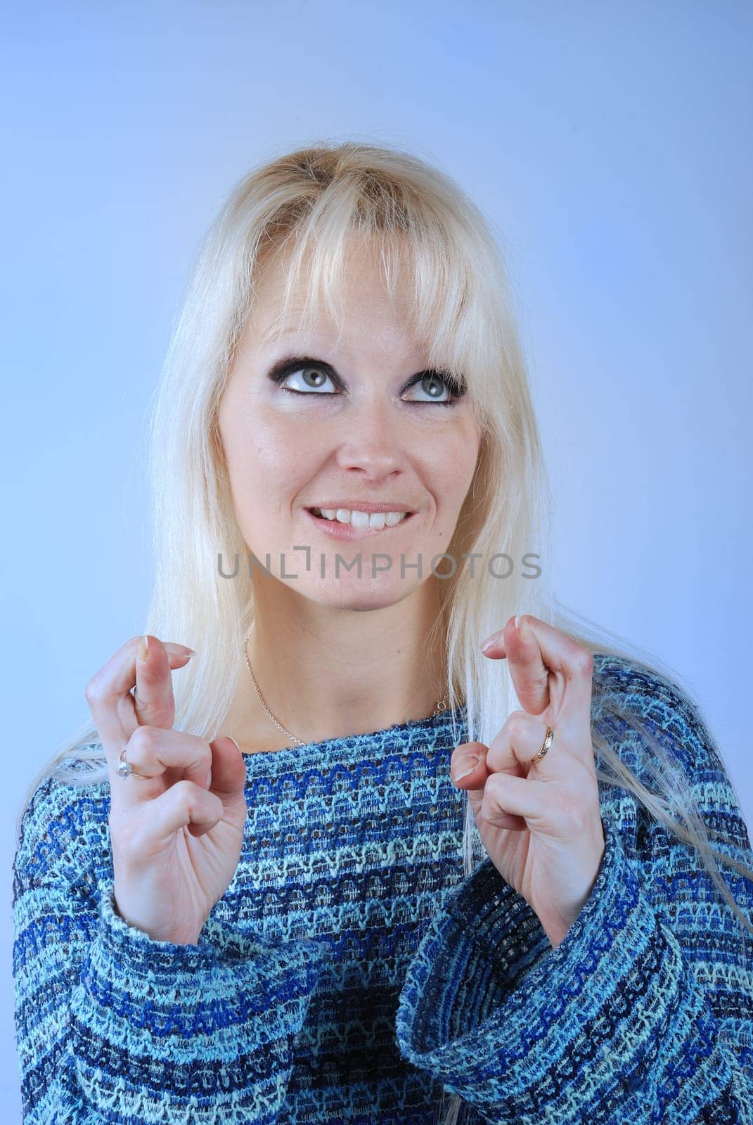 Young blond woman fingers crossed