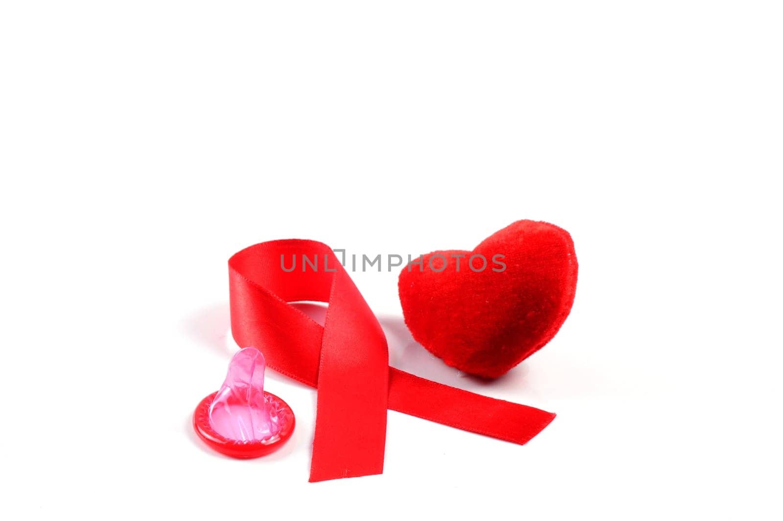 Aids ribbon, condom and heart on white background.
