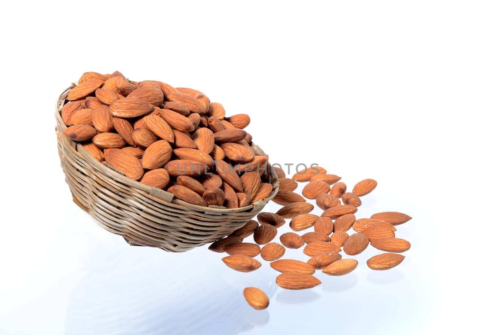 Almonds in a wooden basket with heap isolated on a white background