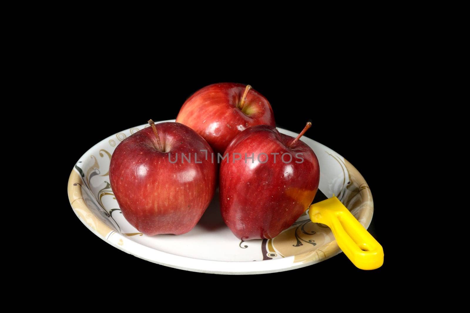 Ripe Red Apples in plate on black background