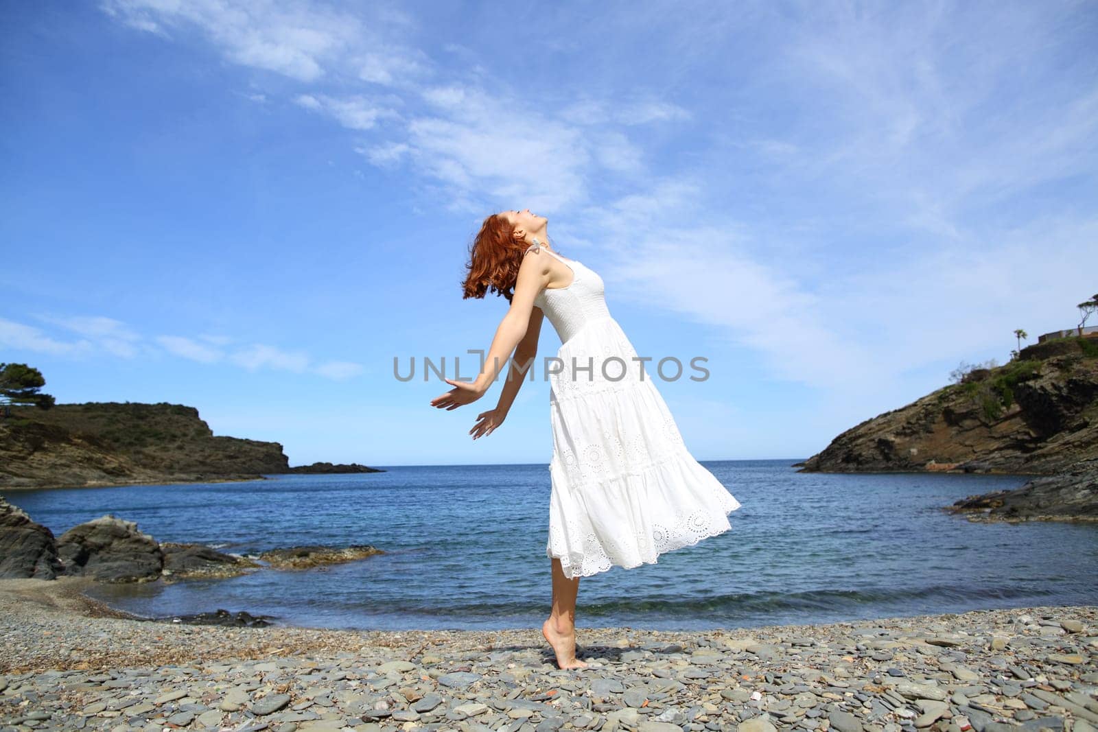 Happy woman in white breaths smiling on the beach