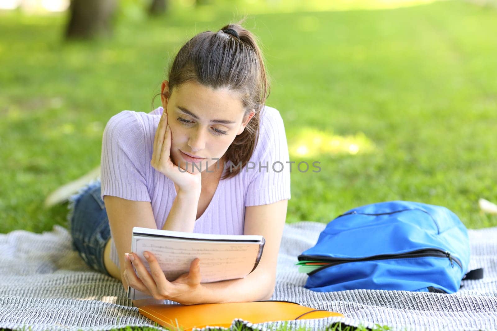 Student studying reading notes in a campus