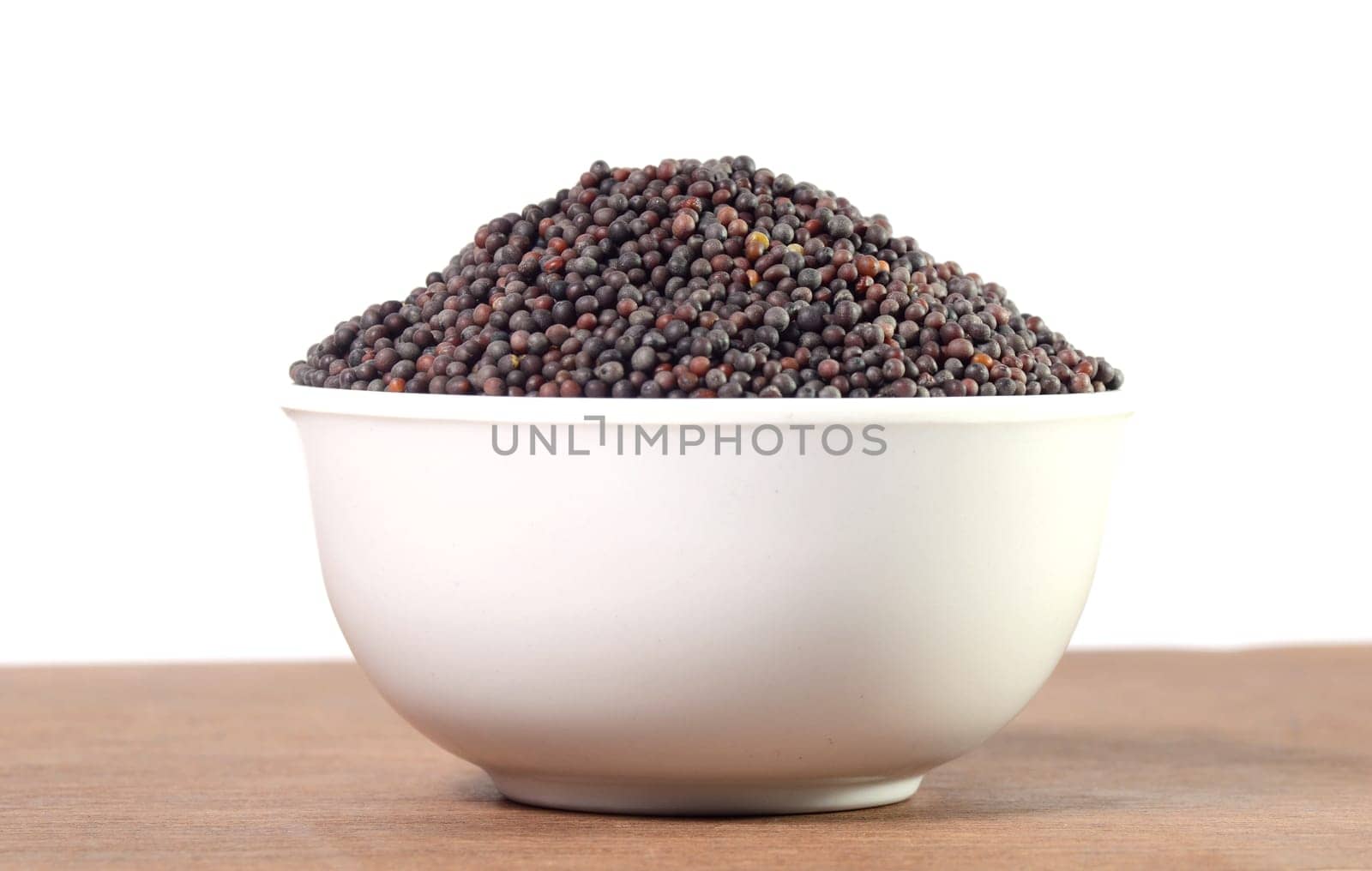 Brown Mustard Seeds in bowl on wooden background