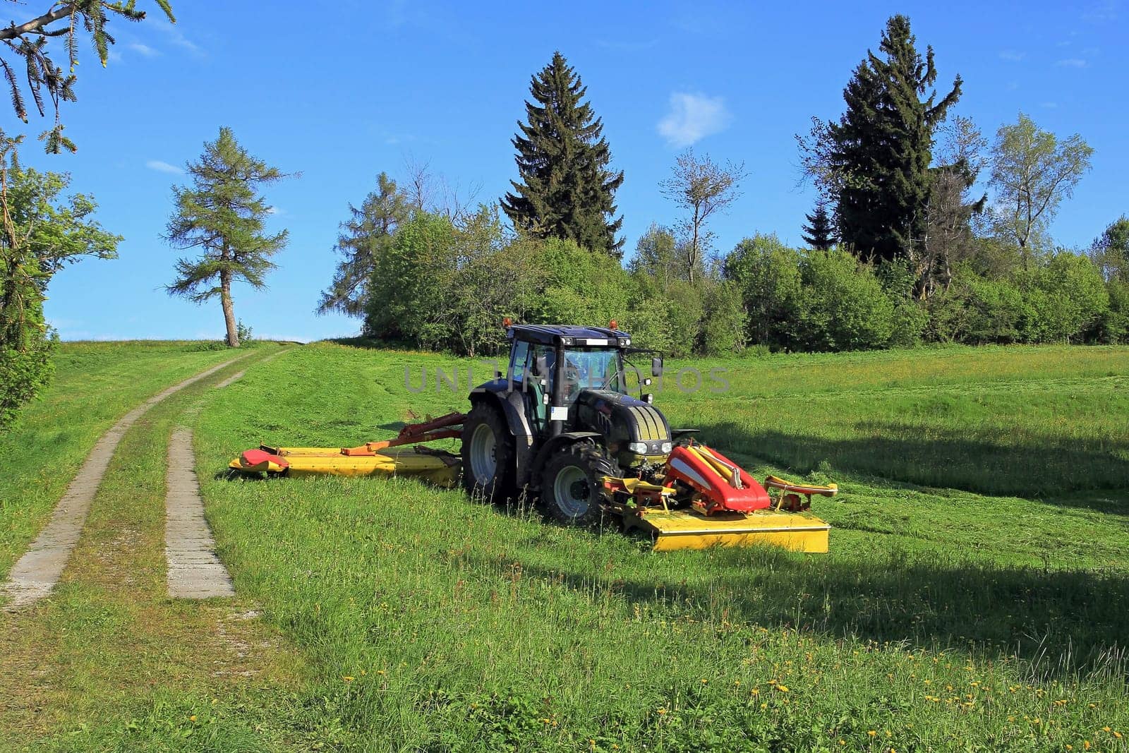 A farmer in Bavaria cuts the grass in a field in summer