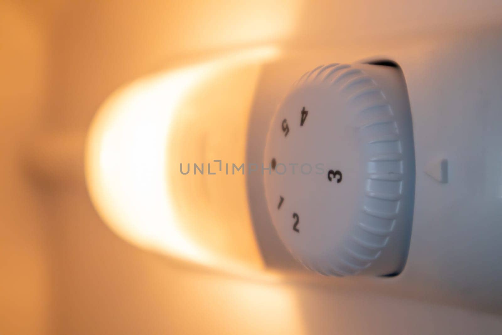 Orange light inside the refrigerator close-up. A lamp that turns on when the door is open to improve vision. Household appliances concept, changing the lamp in the freezer