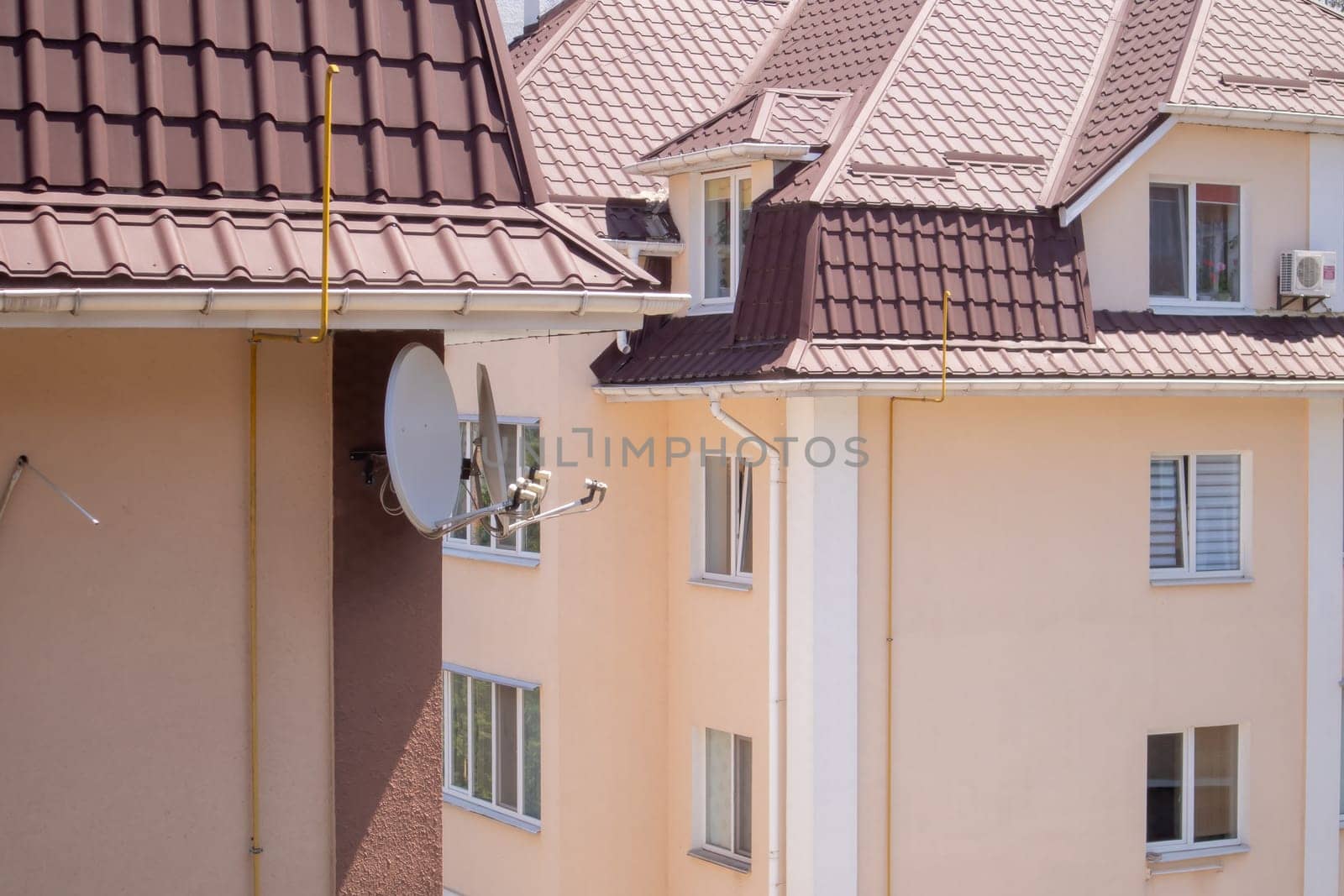 Roof on residential property with new brown corrugated metal roof tiles. Modern metal roof. Metal roofing