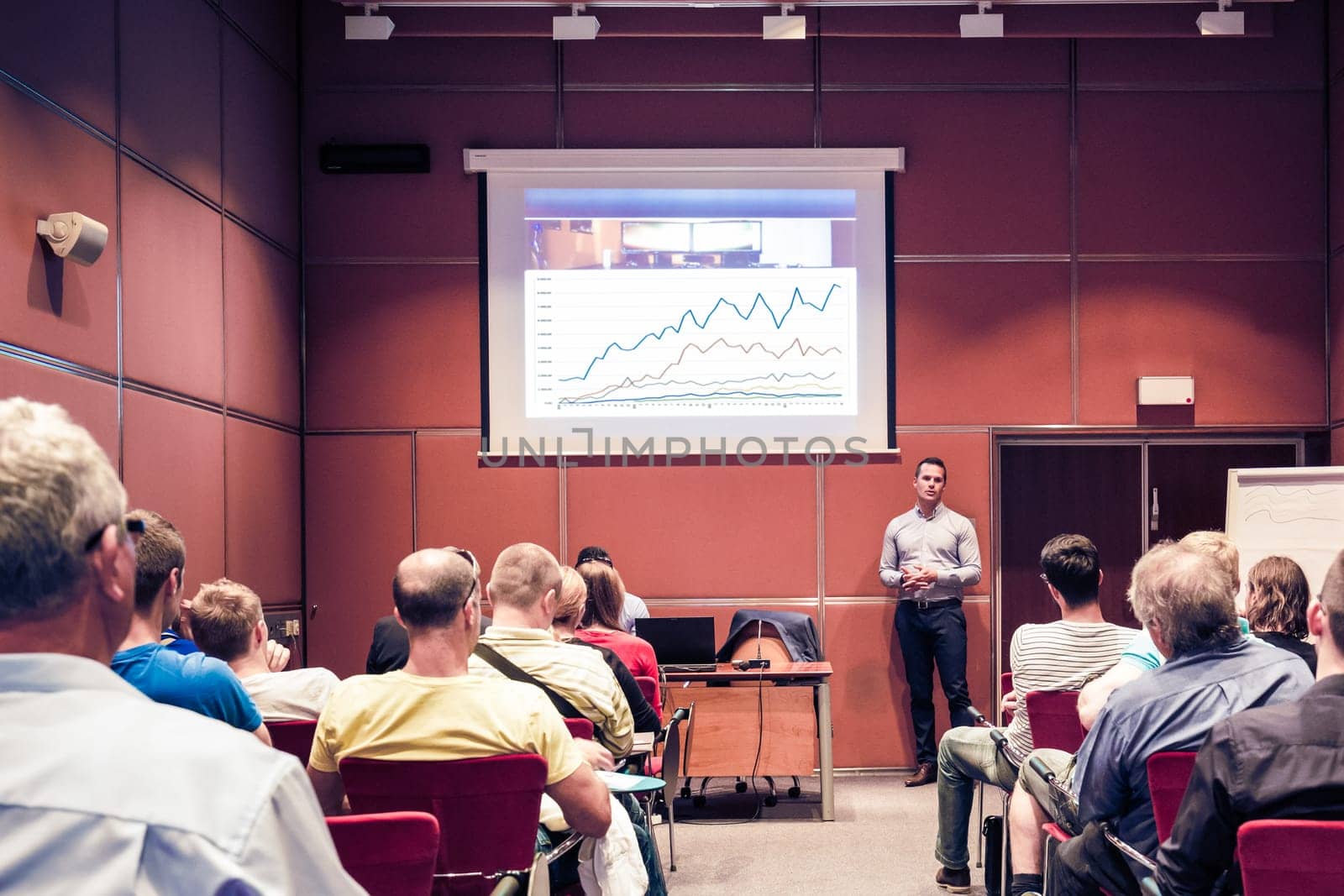 Speaker giving a talk in conference hall at business event. Unrecognizable people in audience at conference hall. Business and Entrepreneurship concept.