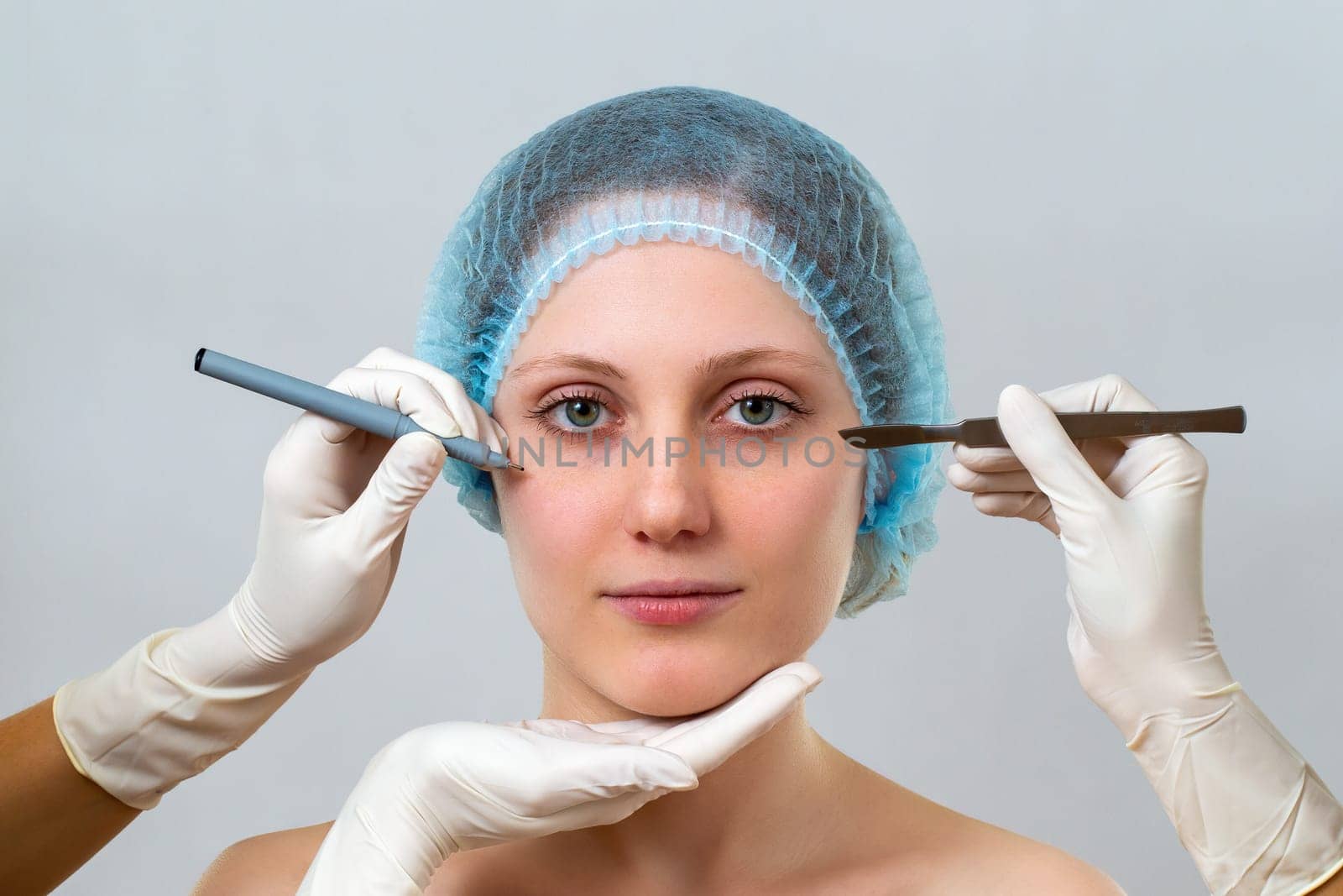 Young woman preparing for plastic surgery in cosmetic clinic. Head of female with hands in gloves with equpment for procedure. Specialists planning rejuvenation.