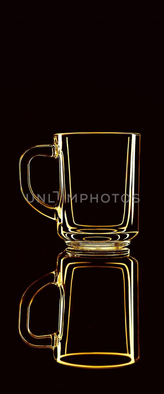Just a glass on a black background with a reflection. Yellow colors. Isolated.