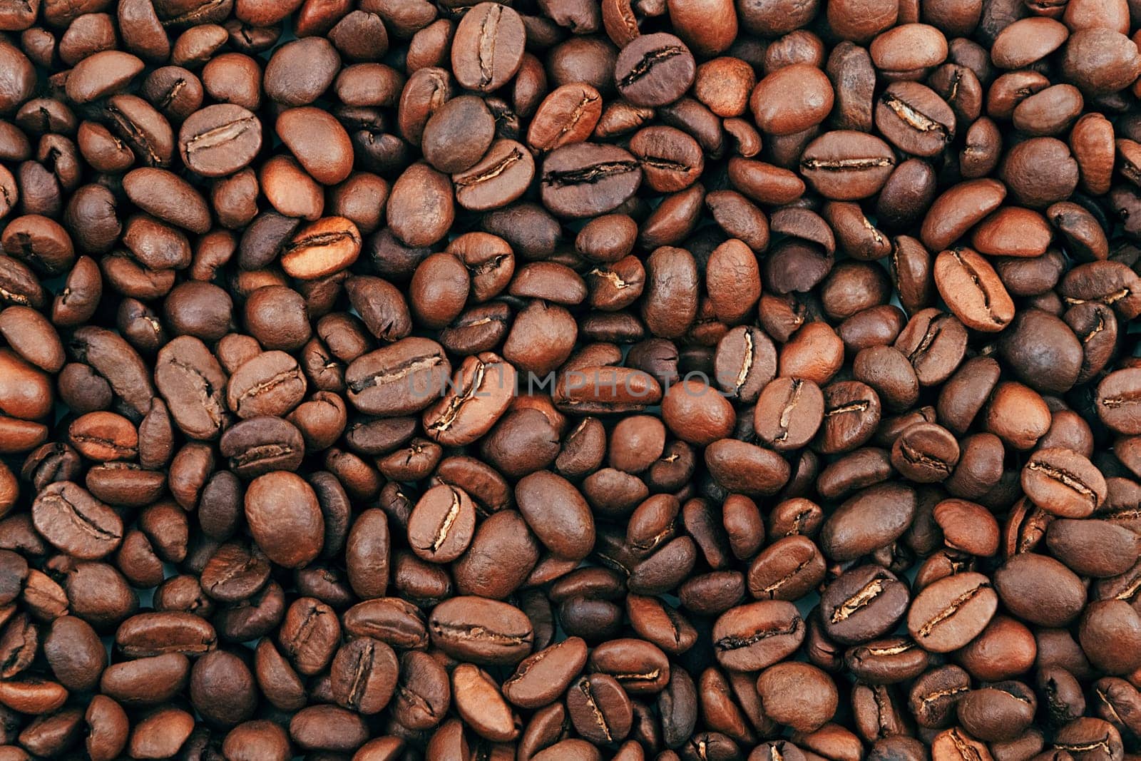Coffee bean background. Dark, brown roasted coffee beans. Scattered coffee beans. Background for advertising, layout, mockup.