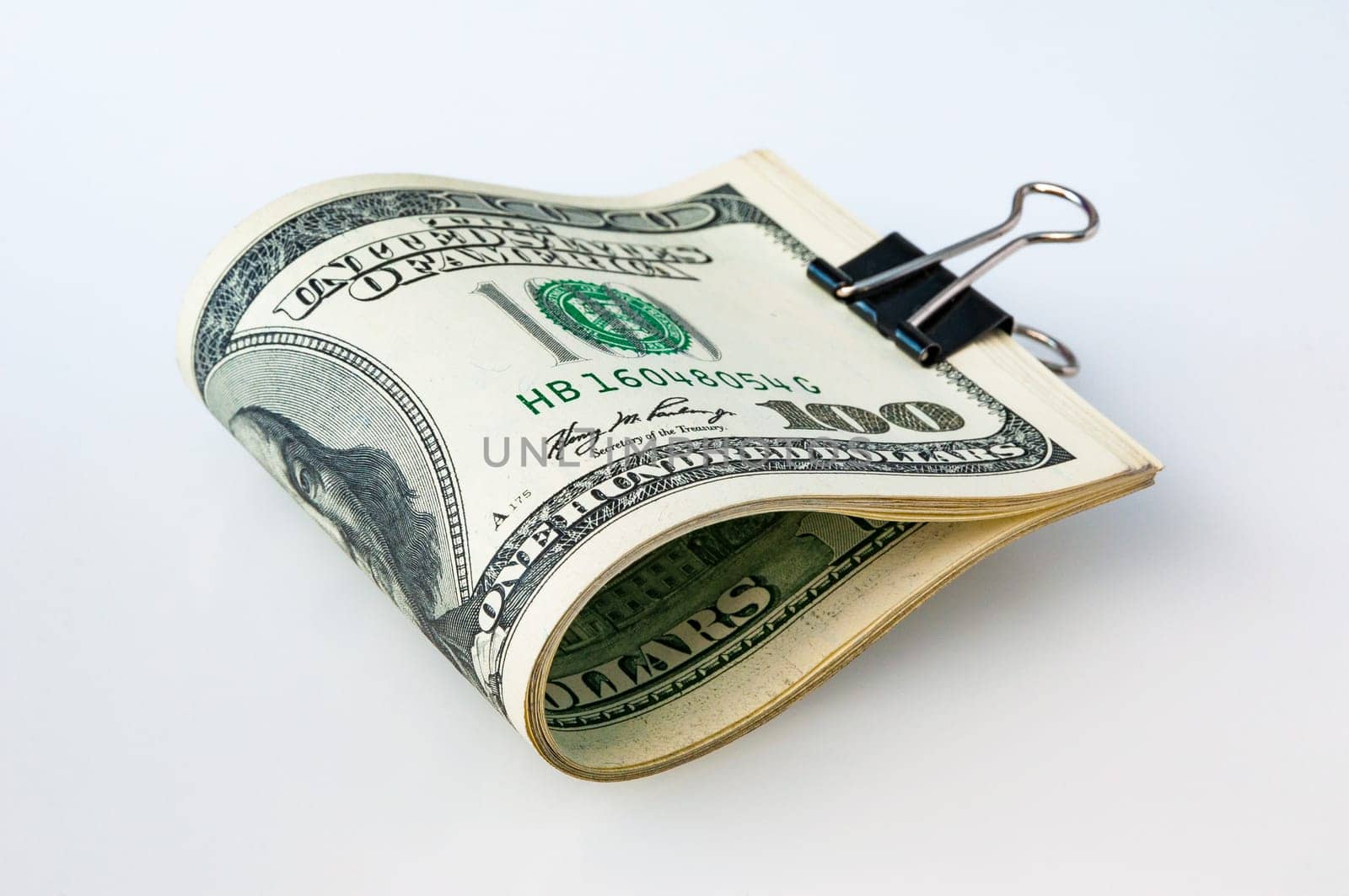 A stack of packaged dollars on a white background. One hundred American dollar bills. The pile of dollars is isolated with a shadow. A big wad of dollars. Place for logo, lettering, layout, layout.