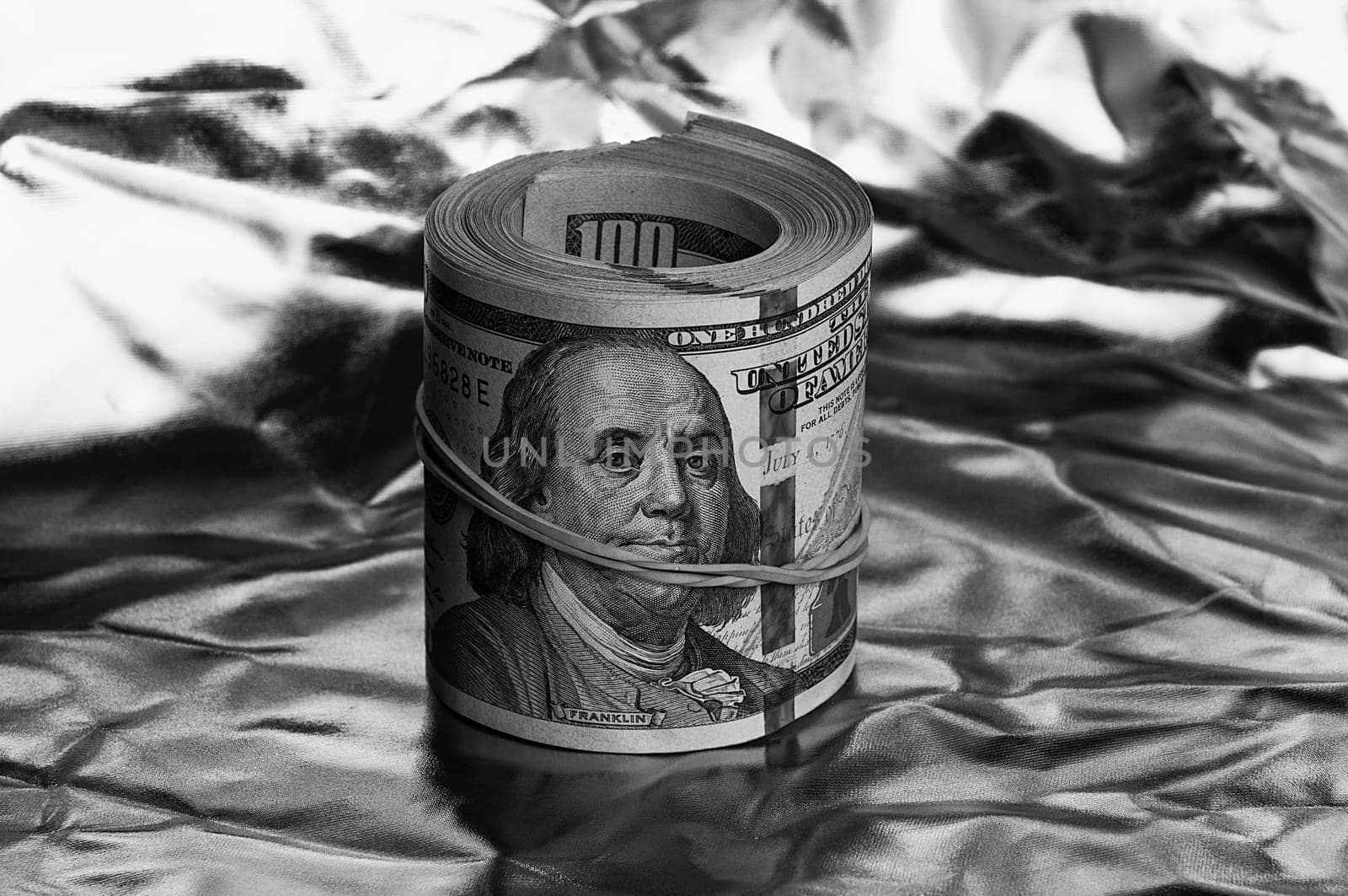 Roll of one hundred American dollars close-up black and white style. A big pile of cash dollars. One hundred dollar bills. Close-up, free space for captions and text.