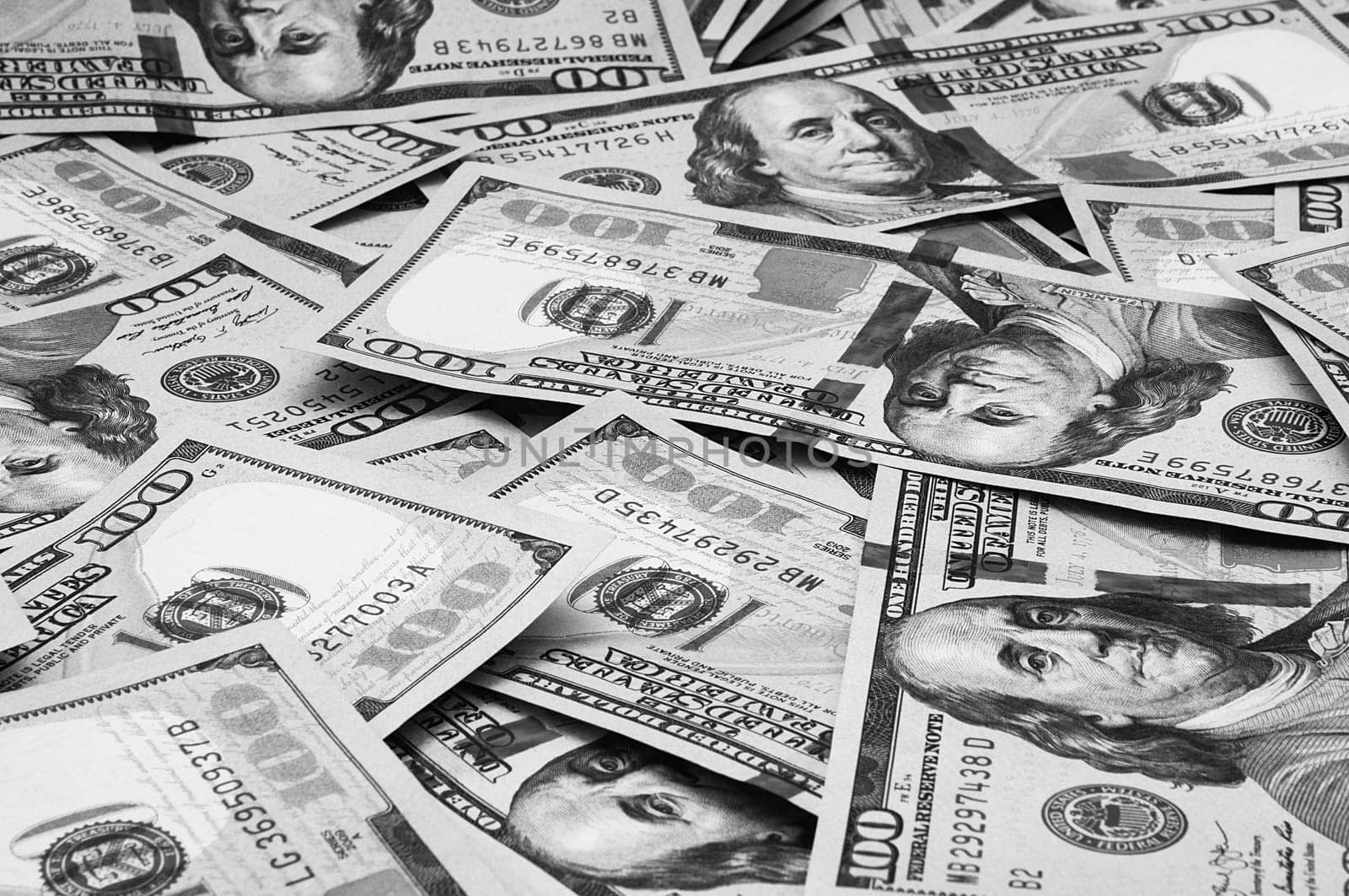 Cash hundred dollar bills, dollar background image. Scattered dollars. A big pile of dollars. Background of North American dollar bills. Black and white style. Top view for collage and presentation editing.