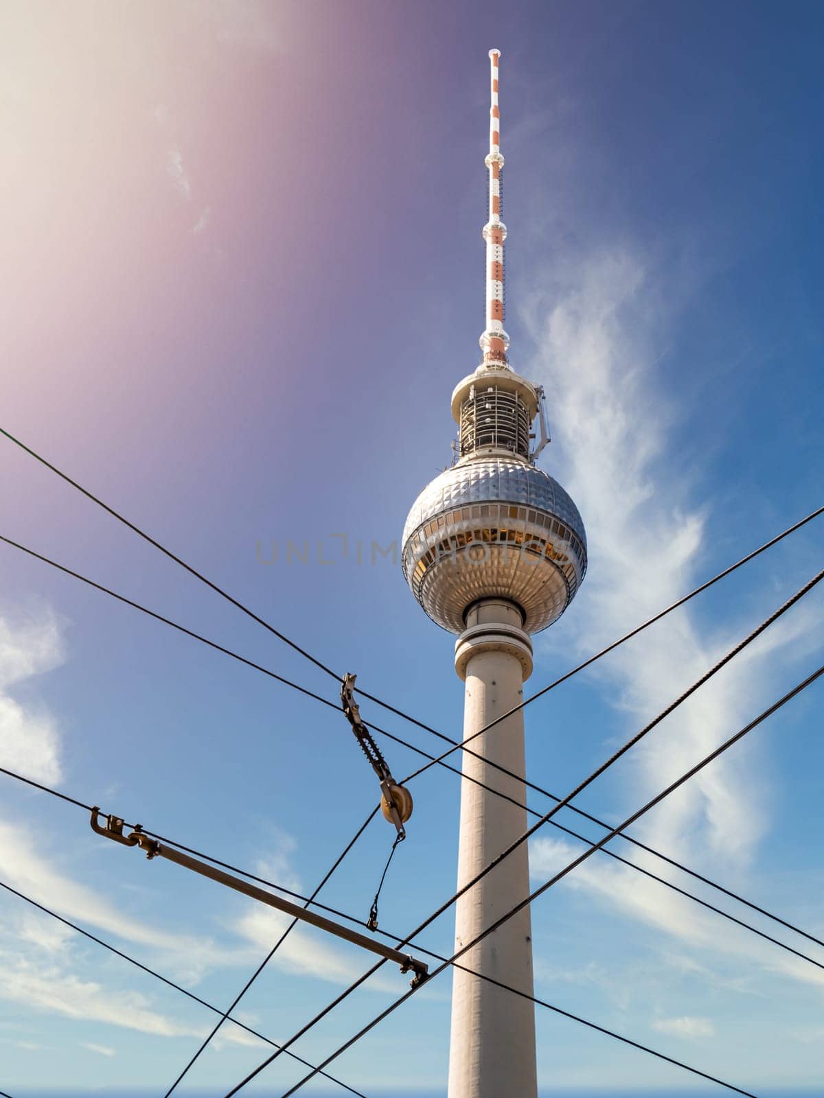 Berlin Television Tower from low angle with cable in forefront during summer with sunflare, germany