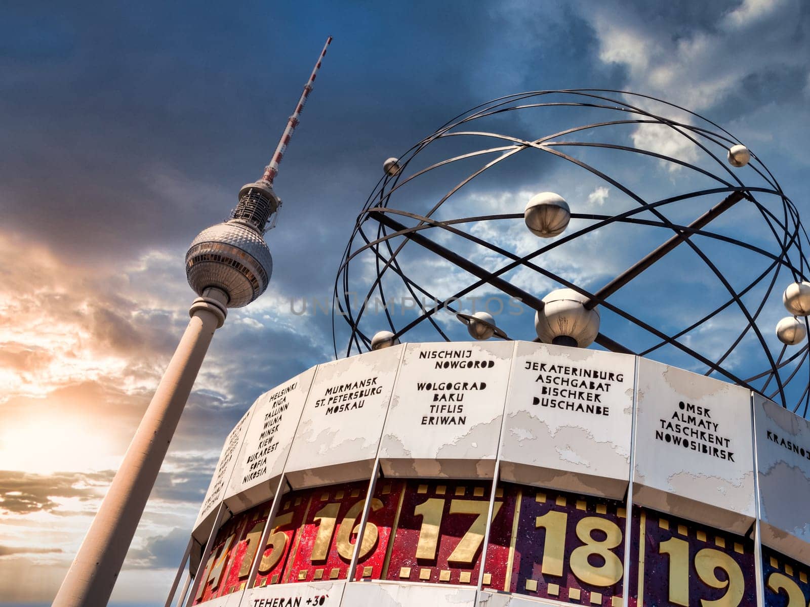 Berlin Television Tower, low angle with World clock in forefront. Sunset with cloudy sky...