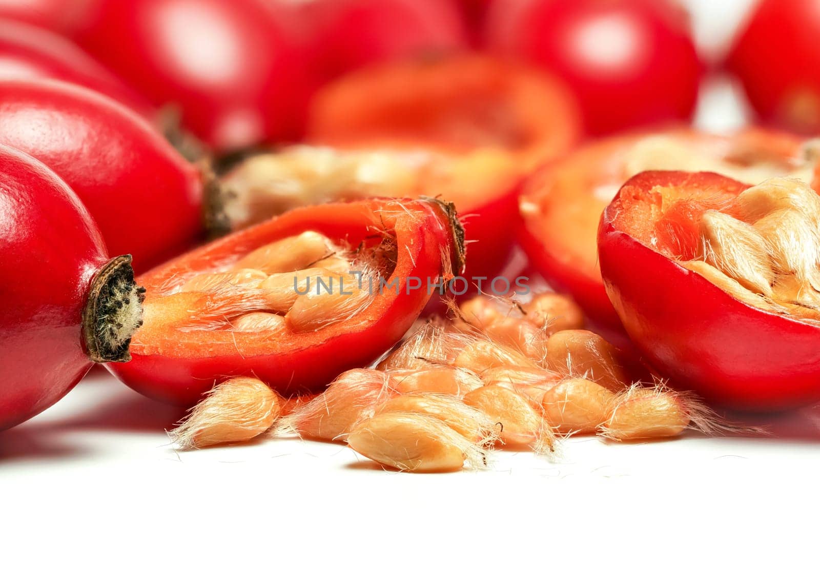 Rosehips Rosa Canina fruits ,cut in half seeds visible macro closeup detail, isolated on white background.