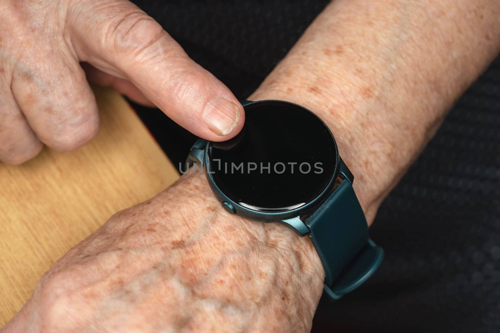 Smart watch black screen - add your graphics on elderly senior hand, closeup detail.
