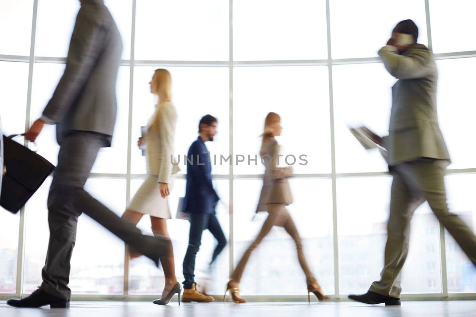 White collar workers going down office corridor at the end of working day