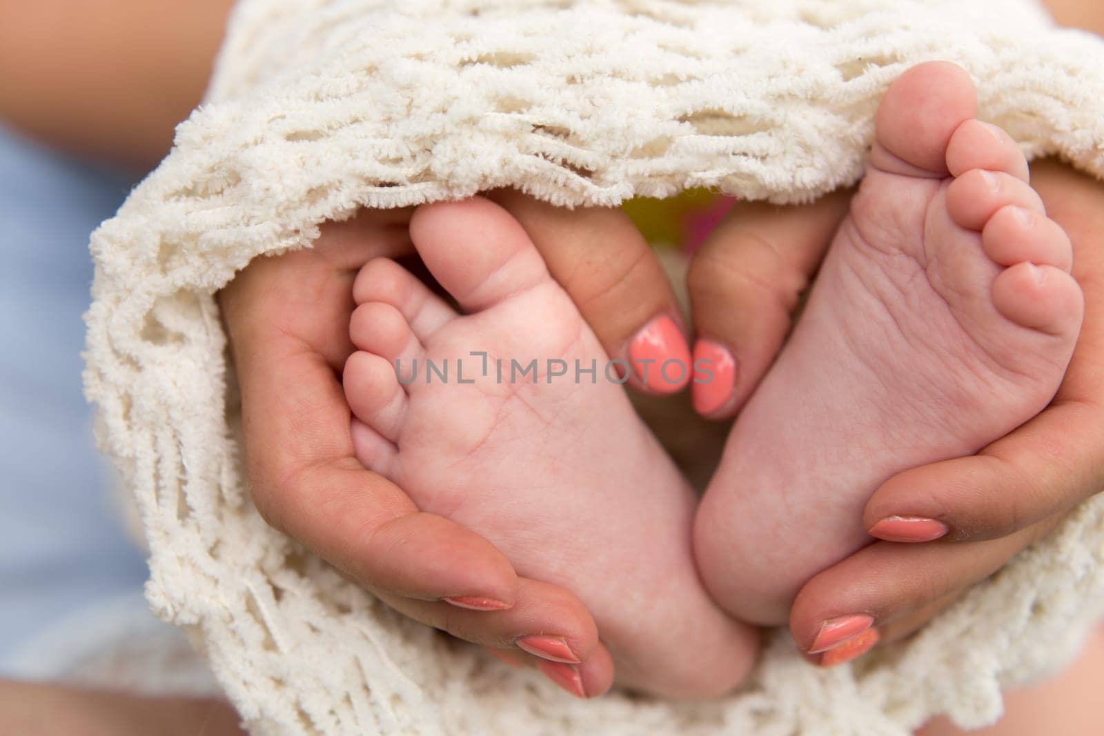 the legs of the child in the mother's arms