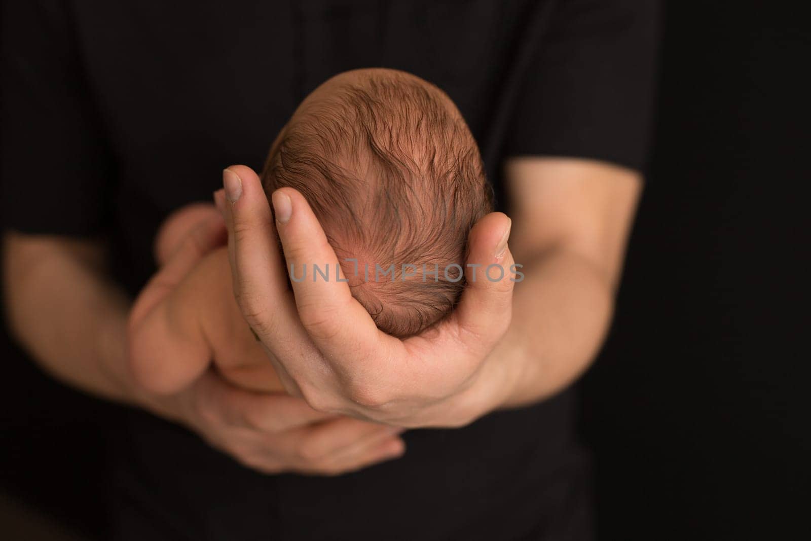 the child's head in the hands of parents. the head of the newbor