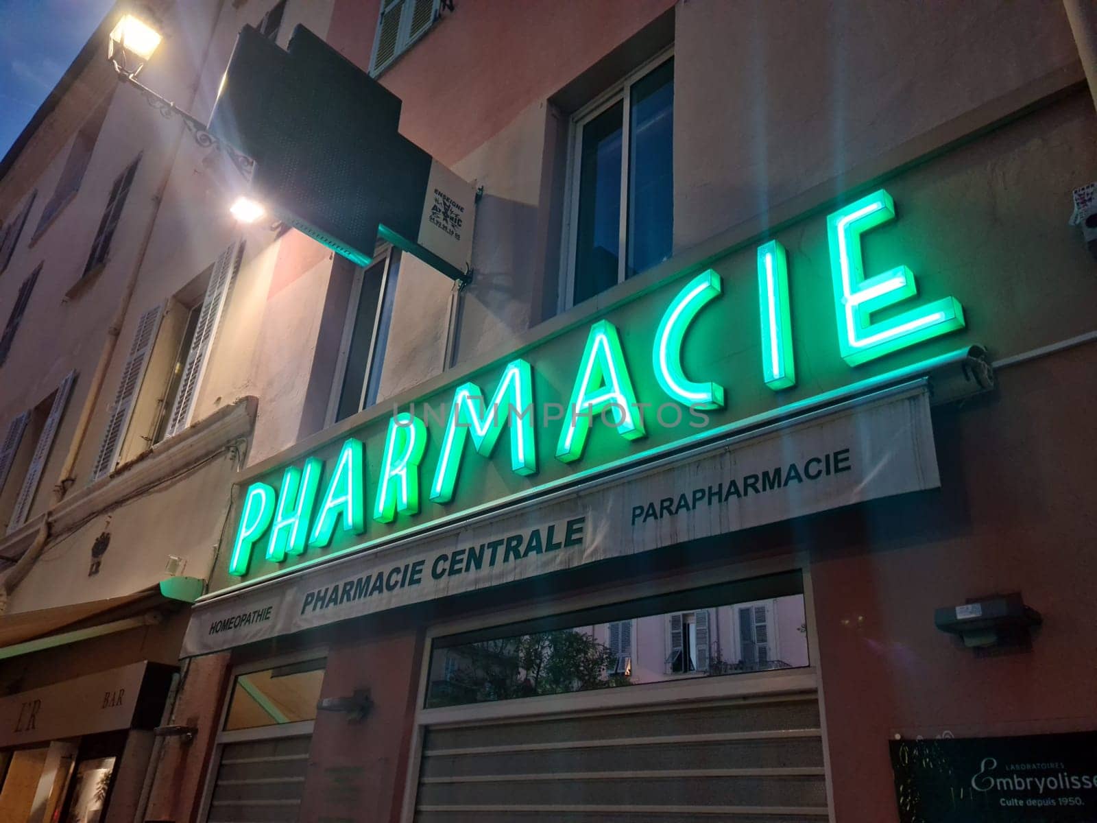 Menton, France - July 2, 2021 : Pharmacy Neon Green Sign Lights, Facade Of A French Pharmacy At Night In Menton, France, Europe