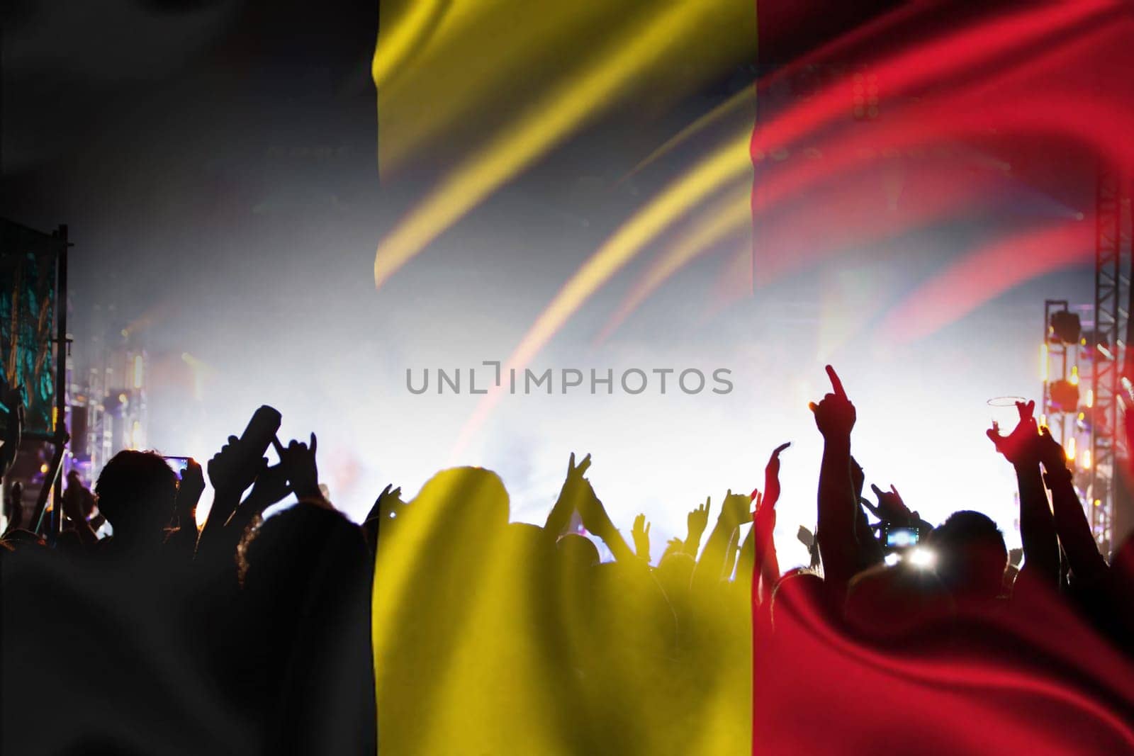 Soccer fans supporting Belgium - crowd celebrating in stadium with raised hands against Belgian flag
