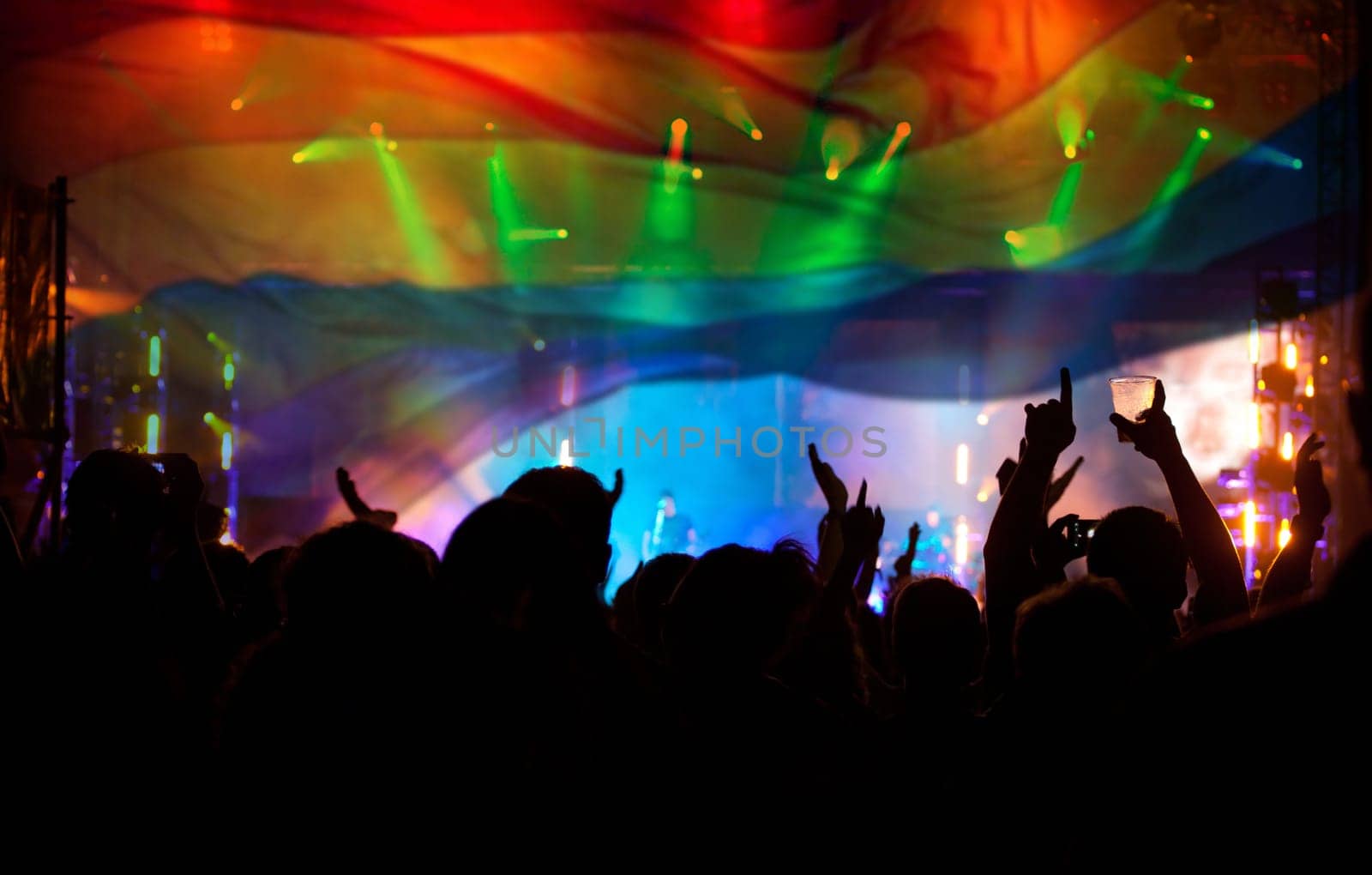 Pride community at a parade with hands raised and the LGBT flag - symbol of love and tolerance