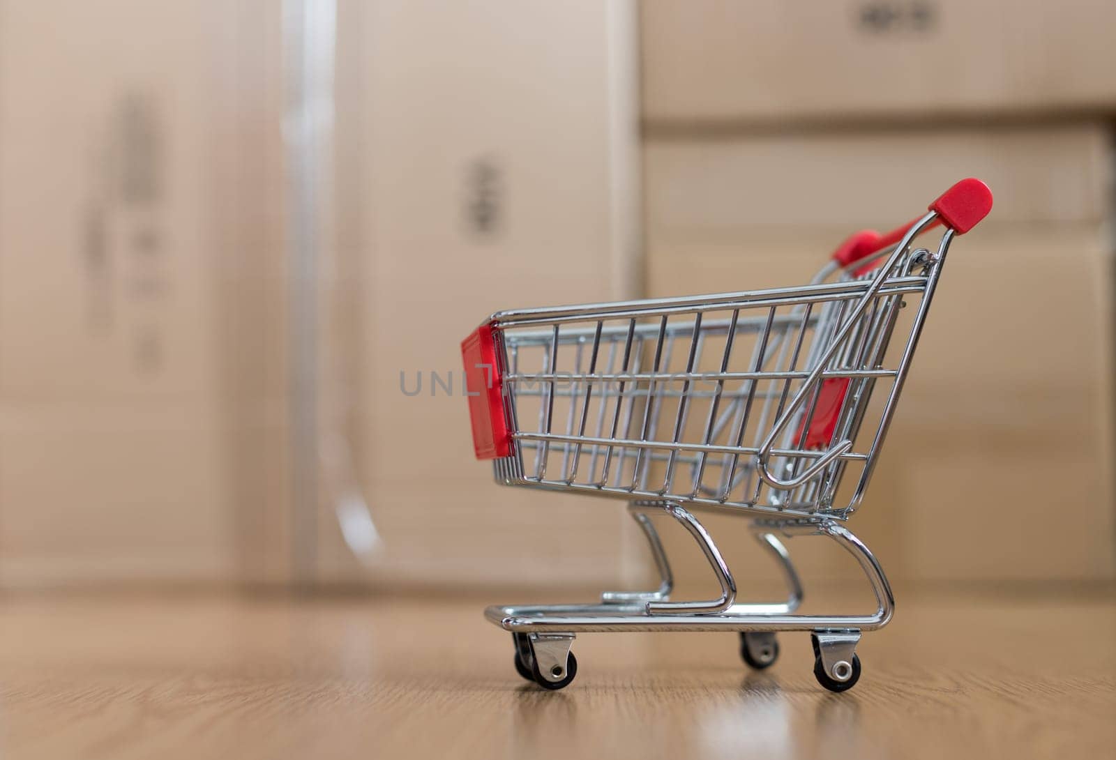 Online-Shopping and parcel service concept: Miniature shopping cart and cardboard boxes