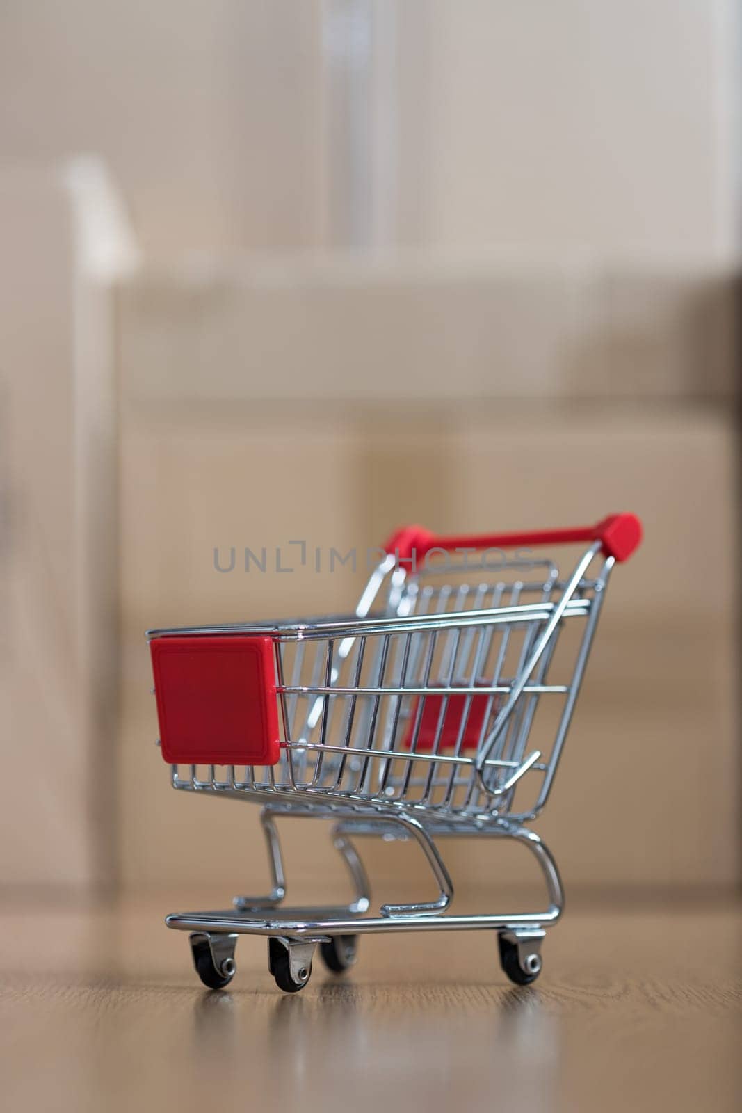 Online-Shopping and parcel service concept: Miniature shopping cart and cardboard boxes