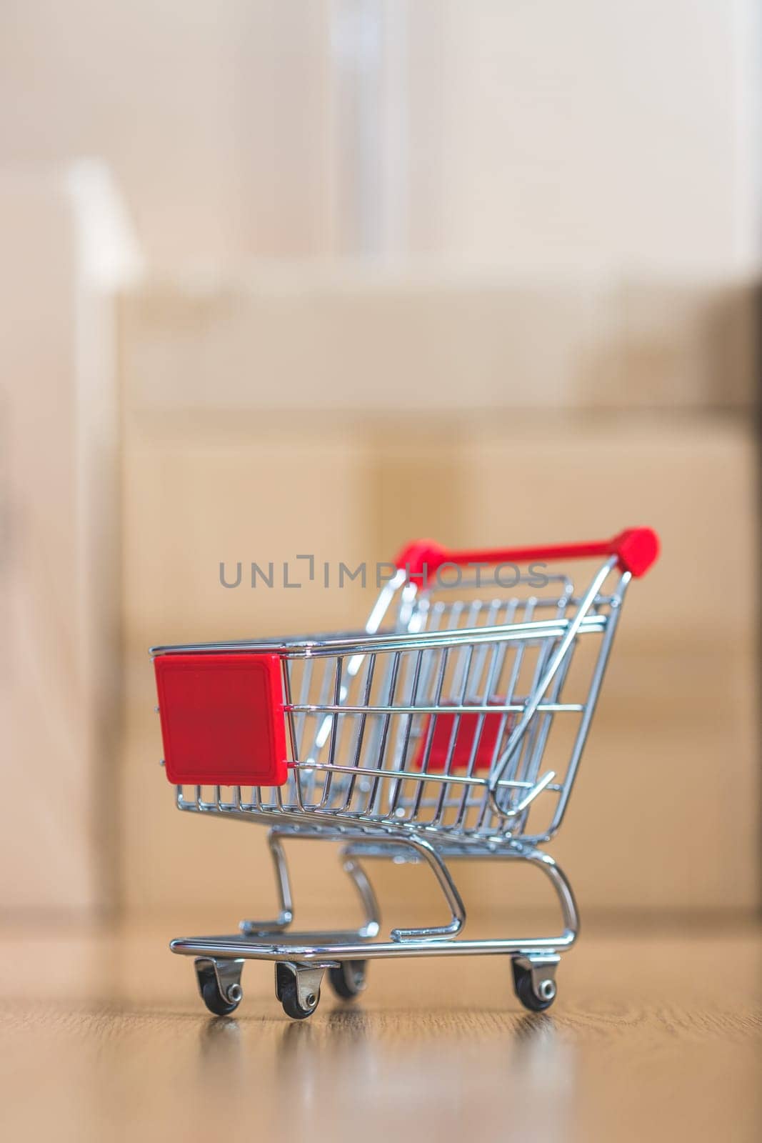 Online-Shopping and parcel service concept: Miniature shopping cart and cardboard boxes