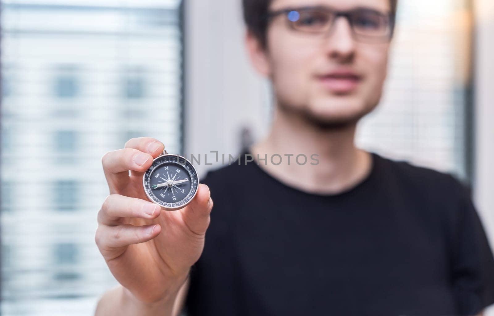 Young freelancer with compass holding in hand