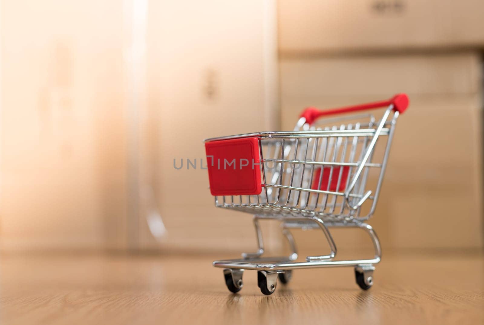 Online-Shopping and parcel service concept: Miniature shopping cart and cardboard boxes