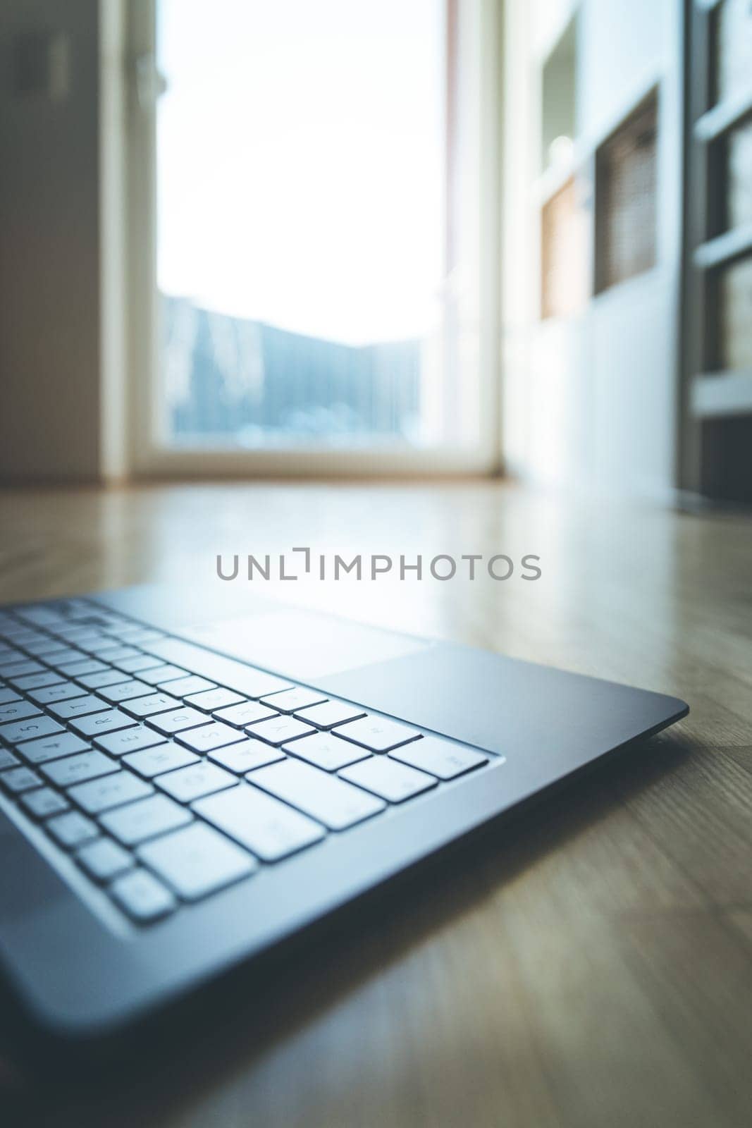 Cutout of a modern laptop keyboard on the wooden floor with text space