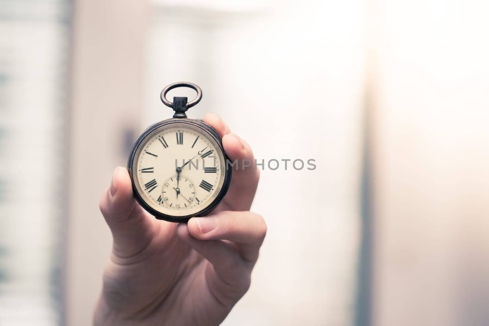 Time goes by: Man is holding a vintage watch in his hand, business context, copy space