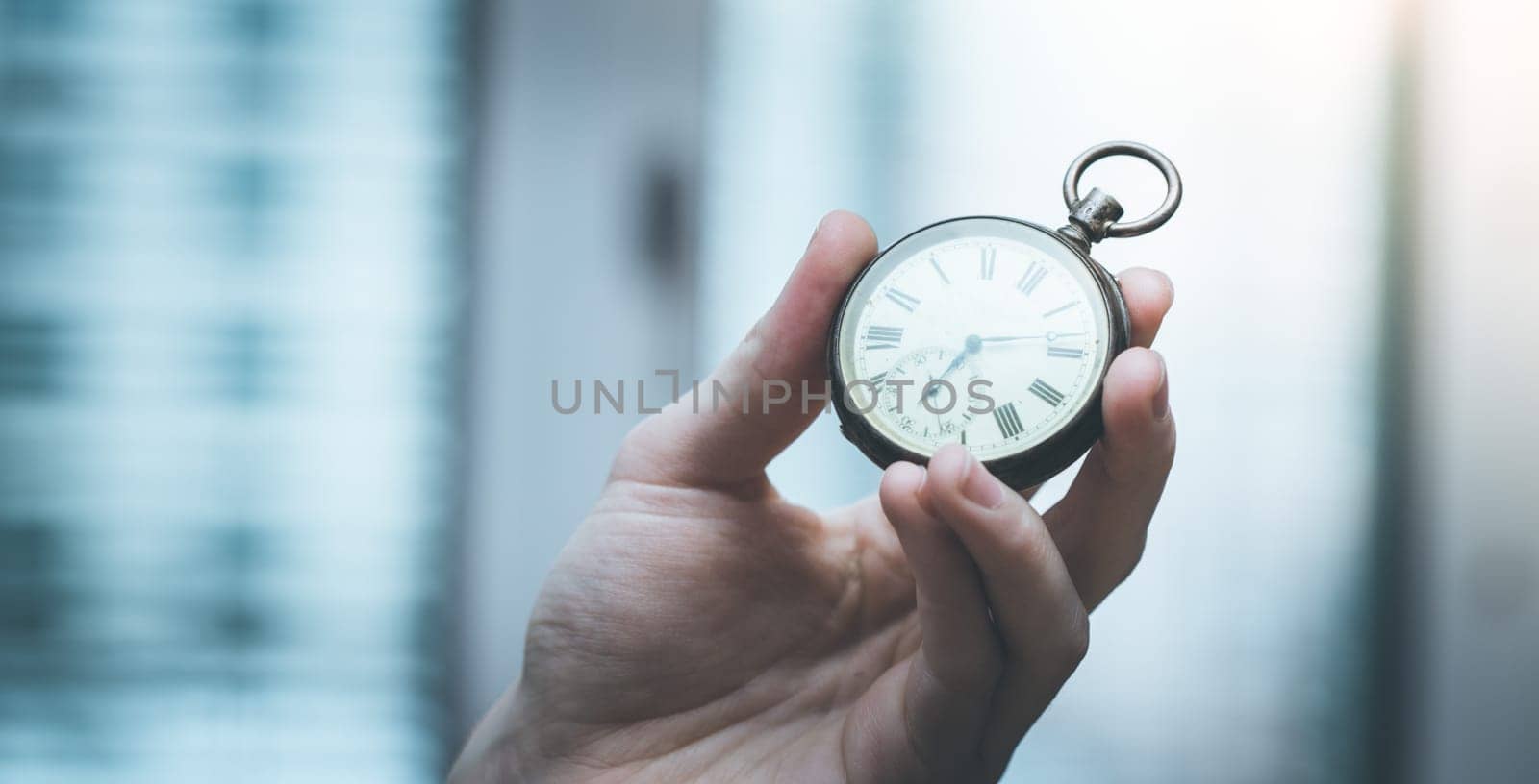 Time goes by: Man is holding a vintage watch in his hand, business context, copy space