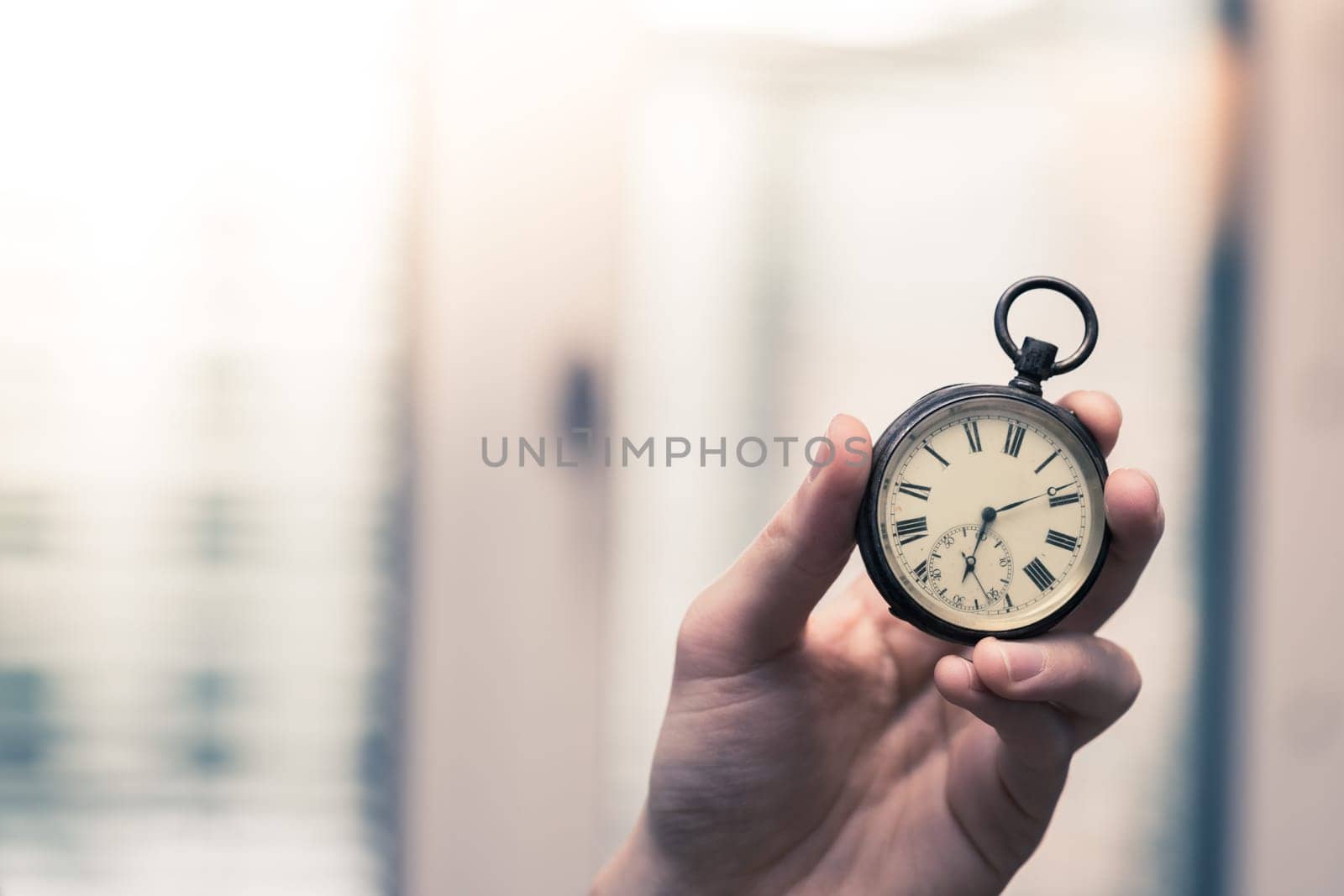 Time goes by: Man is holding a vintage watch in his hand, business context, copy space