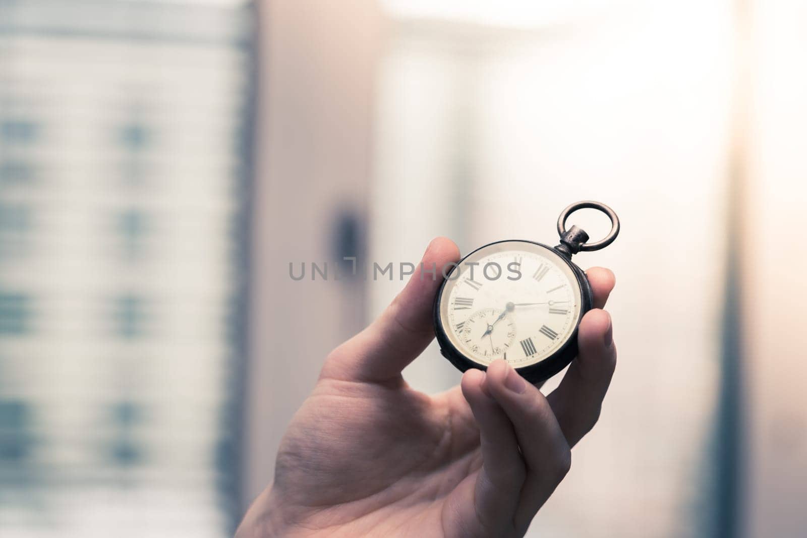 Time goes by: Man is holding a vintage watch in his hand, business context, copy space