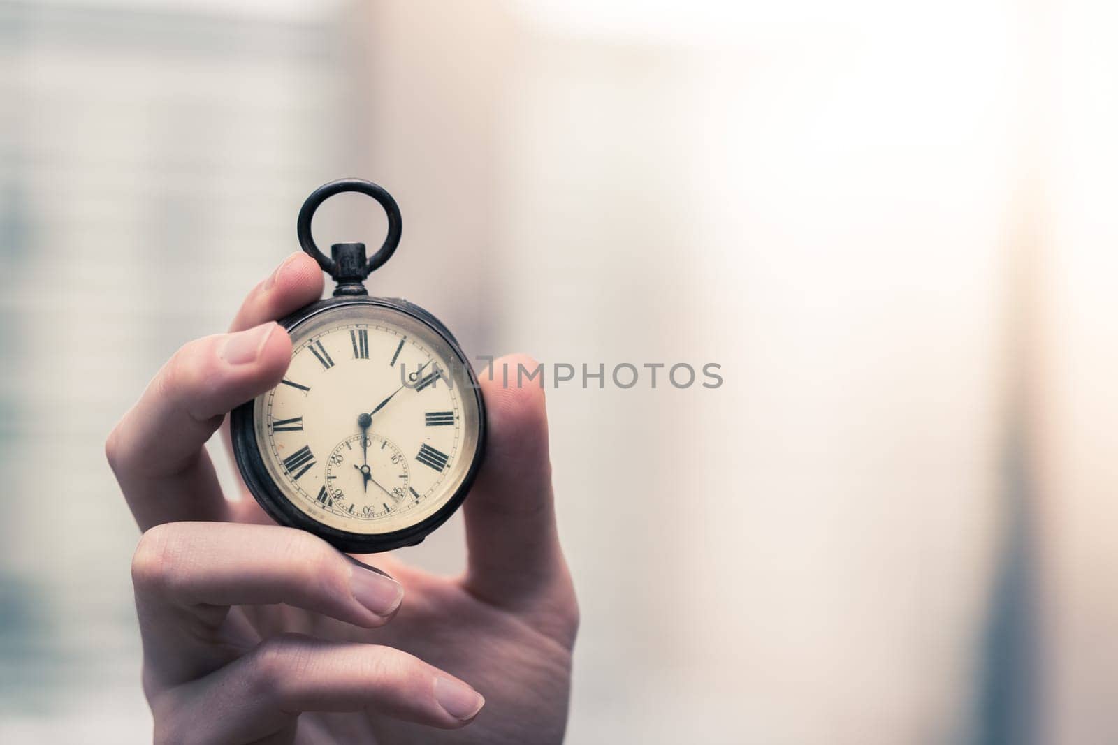 Time goes by: Man is holding a vintage watch in his hand, business context, copy space