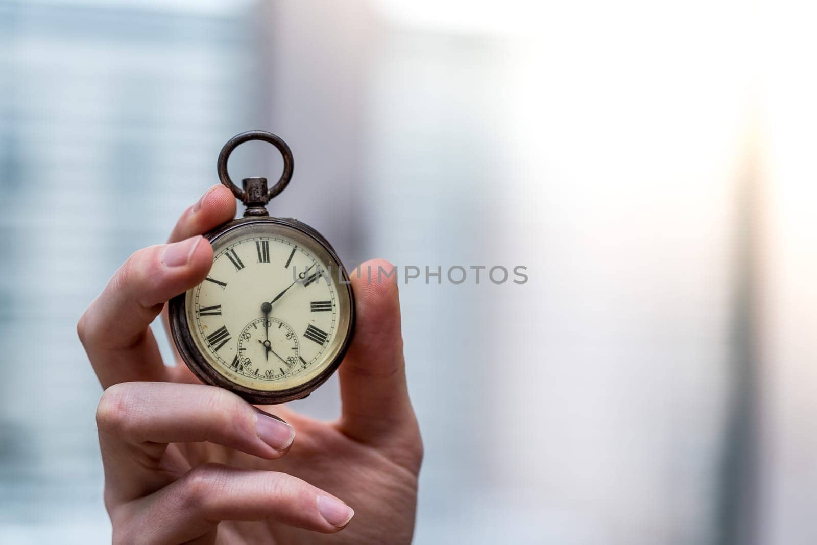 Time goes by: Man is holding a vintage watch in his hand, business context, copy space