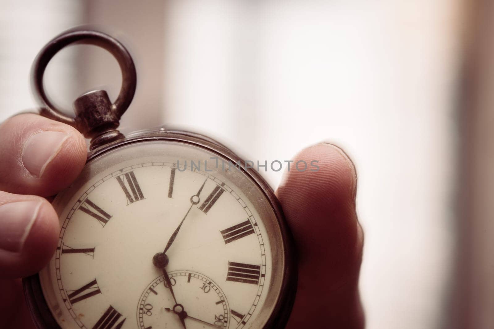 Time goes by: Man is holding a vintage watch in his hand, business context, copy space
