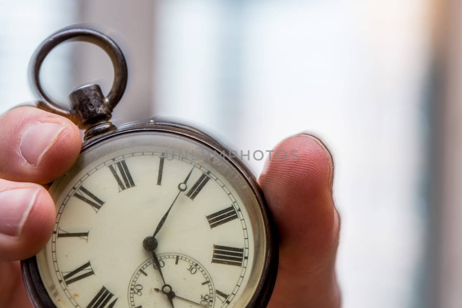 Time goes by: Man is holding a vintage watch in his hand, business context, copy space